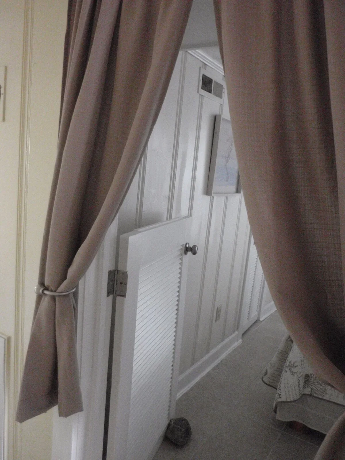 Partial-height white bedroom door with curtains above and beside it