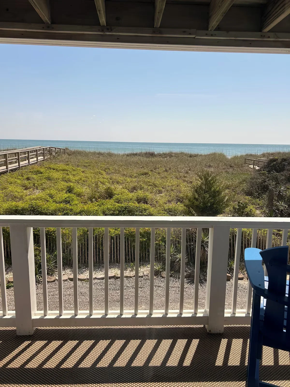 Balcony table and chairs overlooking dune vegetation and the Atlantic
