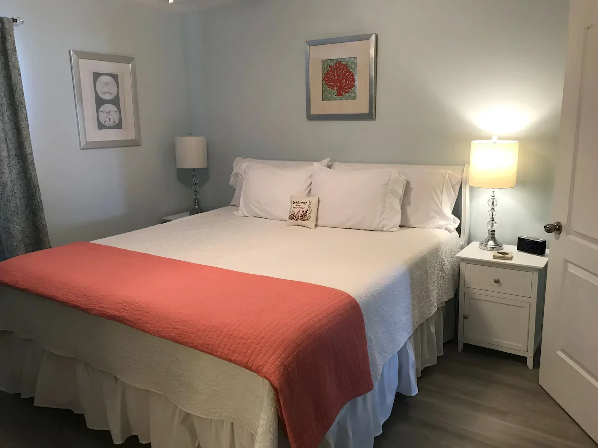 Primary bedroom with a bed, bedside lamps and a red bedcover