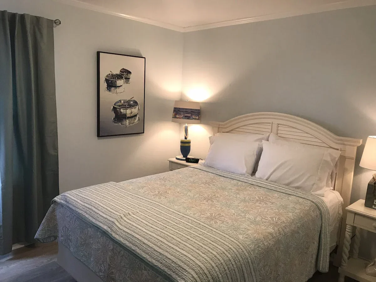 Second bedroom with a bed, lamp and patterned bedcover