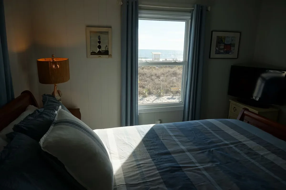 Queen bedroom with a window facing the beach and ocean